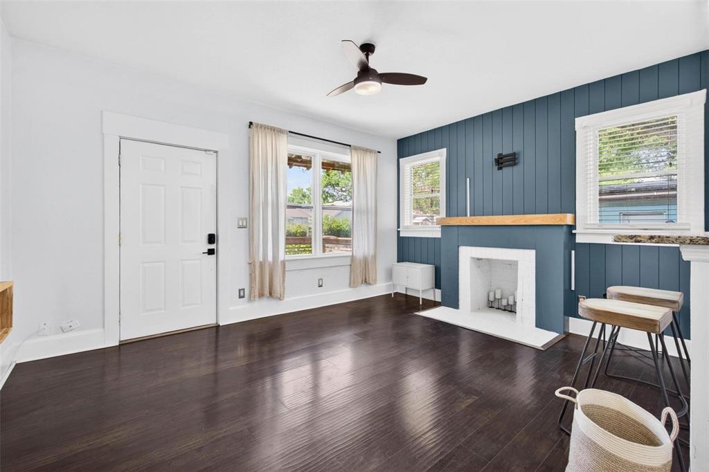 A living room features dark hardwood floors, a blue accent wall, and a white fireplace — 4556 YARMOUTH AVENUE S, ST PETERSBURG, FL