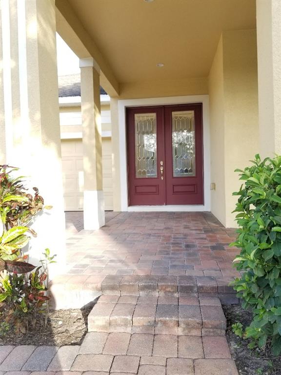A front entryway features a red double door with glass inserts and a paver walkway — 13448 ZORI LANE, WINDERMERE, FL