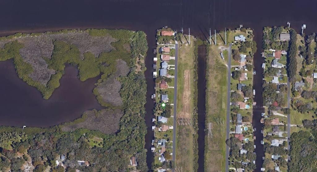 This aerial map view shows residential homes along canals next to a large wooded area — 9919 BAY DRIVE, GIBSONTON, FL