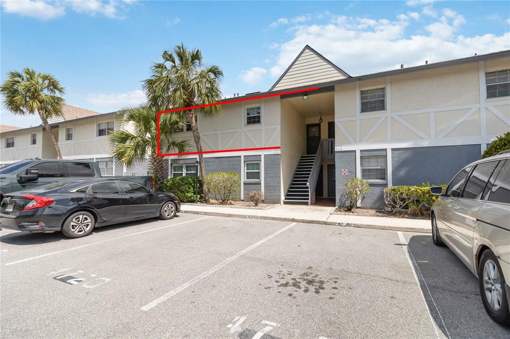 An exterior view of a two-story apartment building with a red rectangle highlighting an upper-level unit — 4722 KILT COURT UNIT 65, ST CLOUD, FL