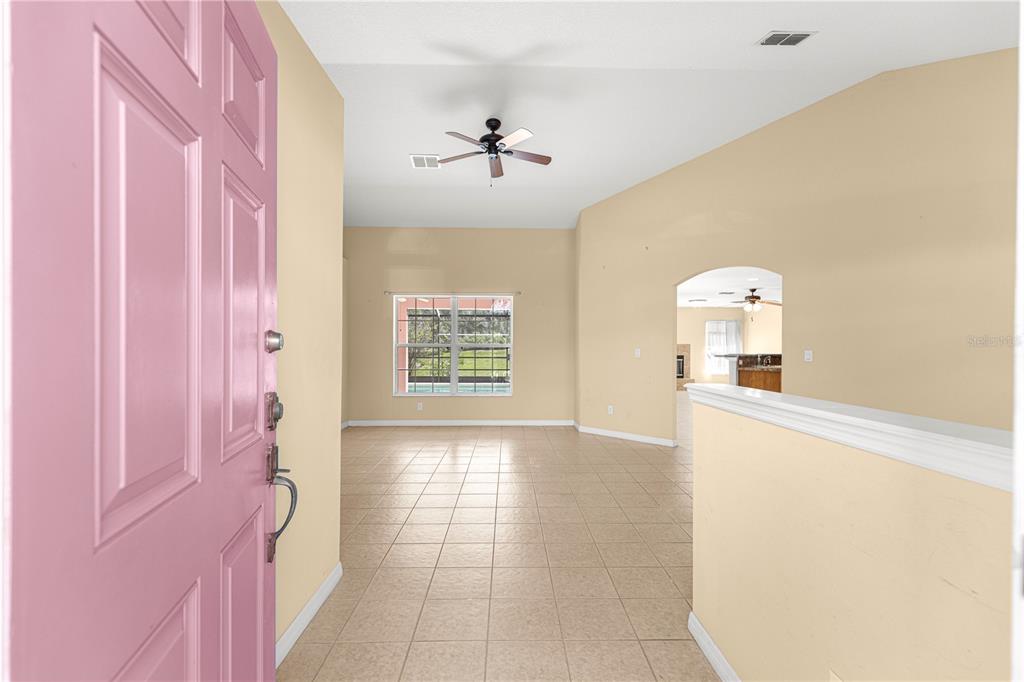 An entryway with a pink door opens into a tiled living area with vaulted ceilings — 4731 SW GARDENIA COURT, DUNNELLON, FL