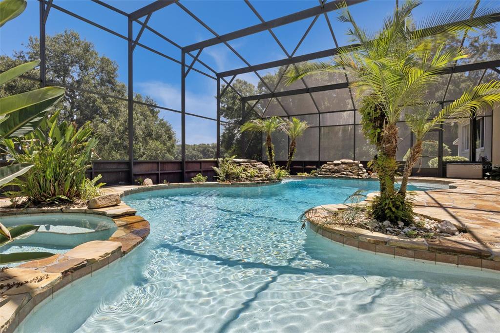 A one-story house with a stone facade, a curved driveway, and manicured hedges — 605 OLD MOUNT DORA ROAD, EUSTIS, FL
