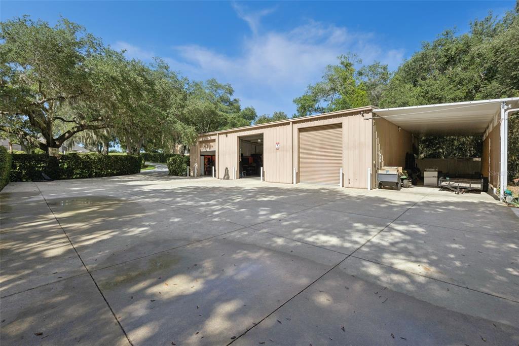 A screened-in swimming pool with a rock waterfall, hot tub, and palm trees — 605 OLD MOUNT DORA ROAD, EUSTIS, FL