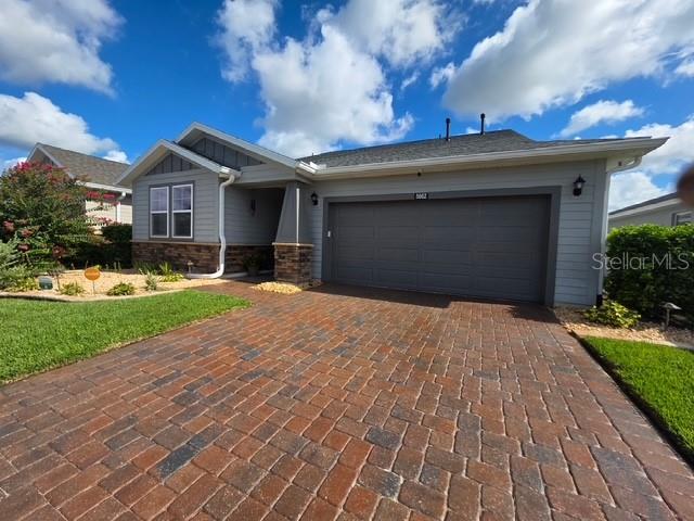 A single-story house features a brick paver driveway, a two-car garage, and gray siding — 5662 NW 40TH LOOP, OCALA, FL