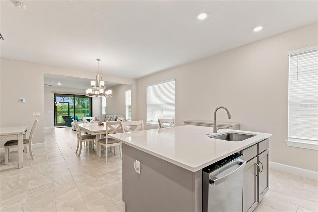 A kitchen featuring gray cabinets, a stainless steel microwave and range, and a white island — 1389 LAMBARDI COURT, POINCIANA, FL