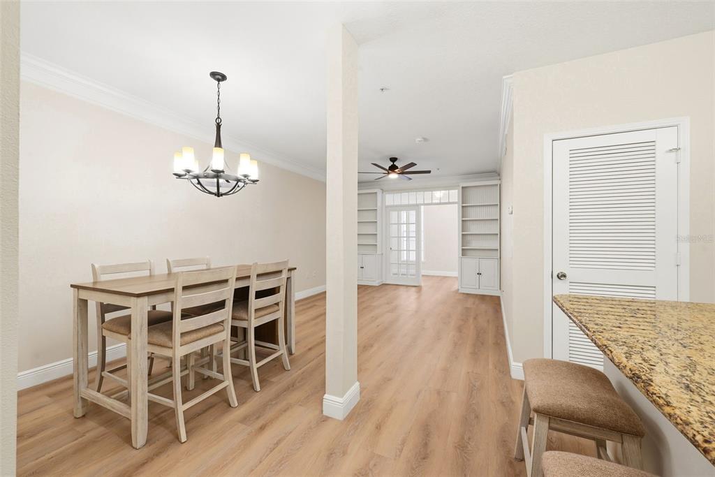 A dining area with a wooden table and chairs sits adjacent to a kitchen counter — 239 LONGVIEW AVENUE UNIT 207, CELEBRATION, FL