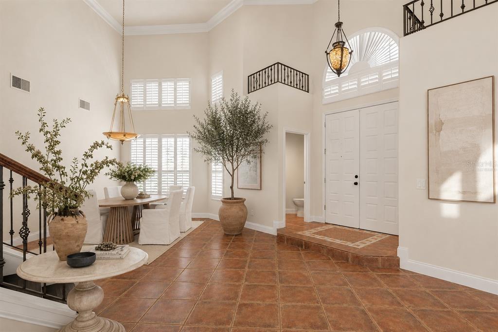 A bright foyer with terracotta tile floors, a dining area, and a high vaulted ceiling — 6 MONTERREY DRIVE, PALM COAST, FL