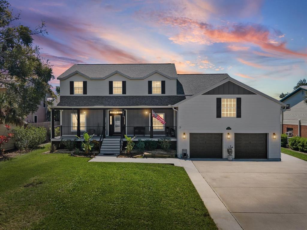 A two-story house with a front porch, attached two-car garage, and a grassy lawn — 1414 DEIRDRE DRIVE, RUSKIN, FL