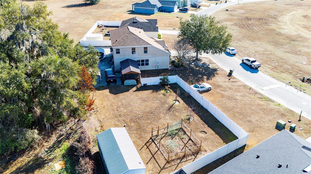 An aerial view shows a two-story house with a fenced backyard, shed, and garden — 2644 SE 75TH BOULEVARD, BUSHNELL, FL