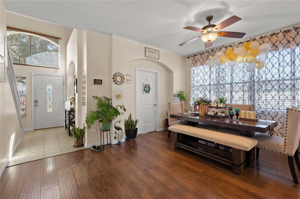 A dining room with wood floors, a wooden table, a bench, and a ceiling fan — 2644 SE 75TH BOULEVARD, BUSHNELL, FL