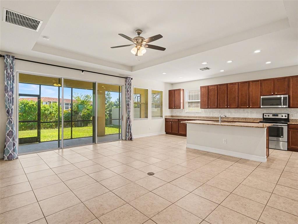A single-story suburban house with a paved driveway and a palm tree at sunset — 4429 CONCHFISH LANE, OSPREY, FL