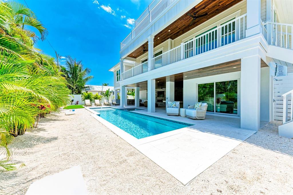 A multi-story house with a white exterior, a swimming pool, and a gravel backyard — 215 83RD STREET, HOLMES BEACH, FL