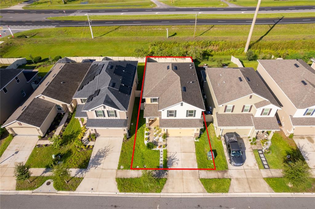 An aerial view shows a two-story suburban house outlined in red with a concrete driveway — 3852 SAGEFIELD DRIVE, HARMONY, FL