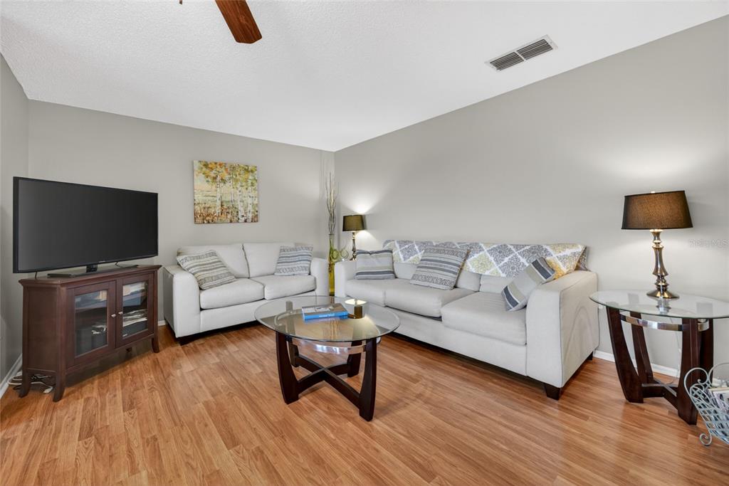A view from an open front door into a hallway with tiled and wood flooring — 6080 80TH STREET N UNIT 409, ST PETERSBURG, FL