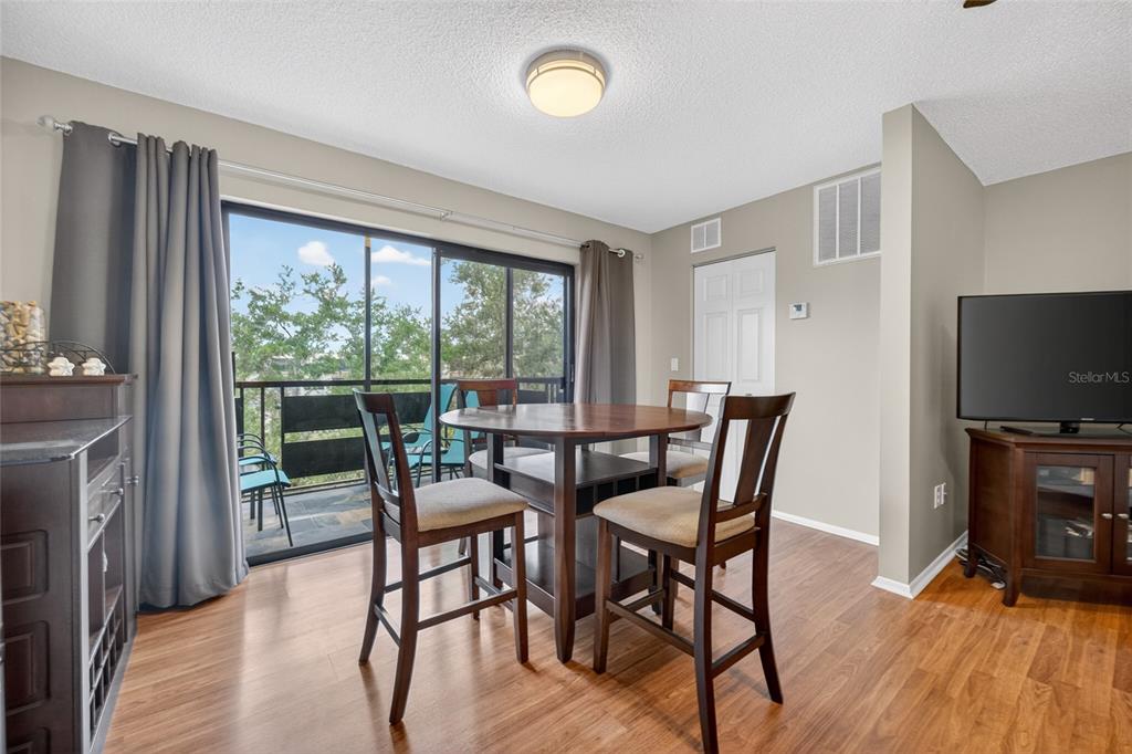 A hallway with wood-look flooring, a mirrored closet, a bench, and a glass-paneled exterior door — 6080 80TH STREET N UNIT 409, ST PETERSBURG, FL