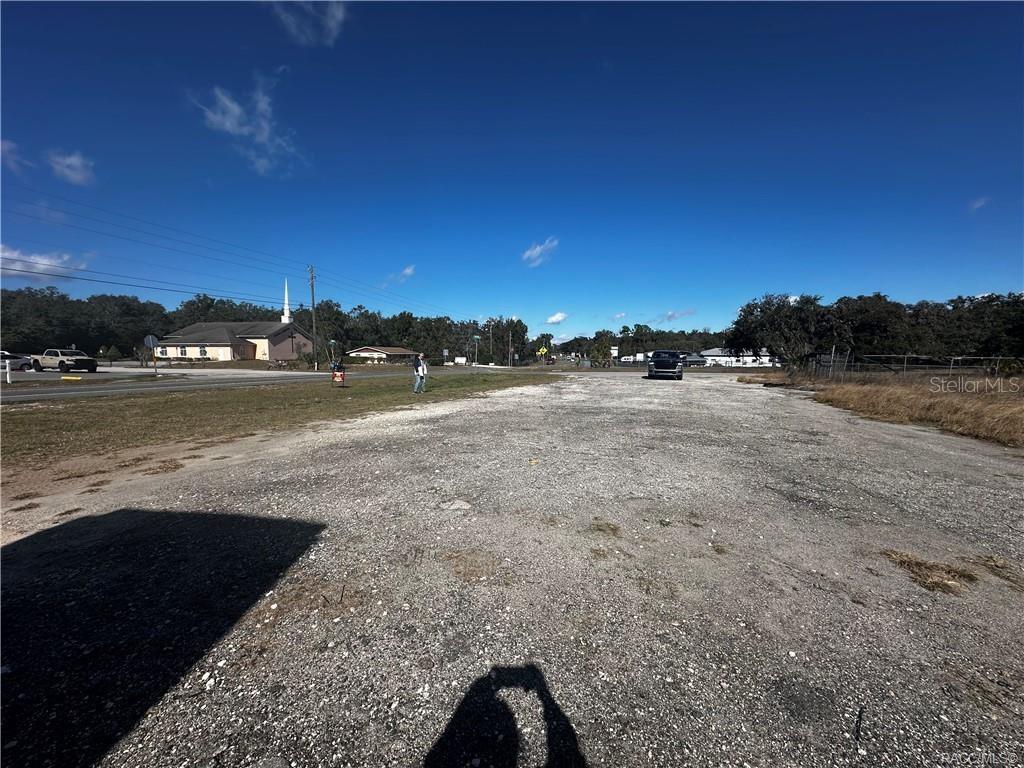 A wide, gravel-covered vacant lot sits alongside a road with a church in the distance — 3172 N AQUAVIEW TERRACE, HERNANDO, FL