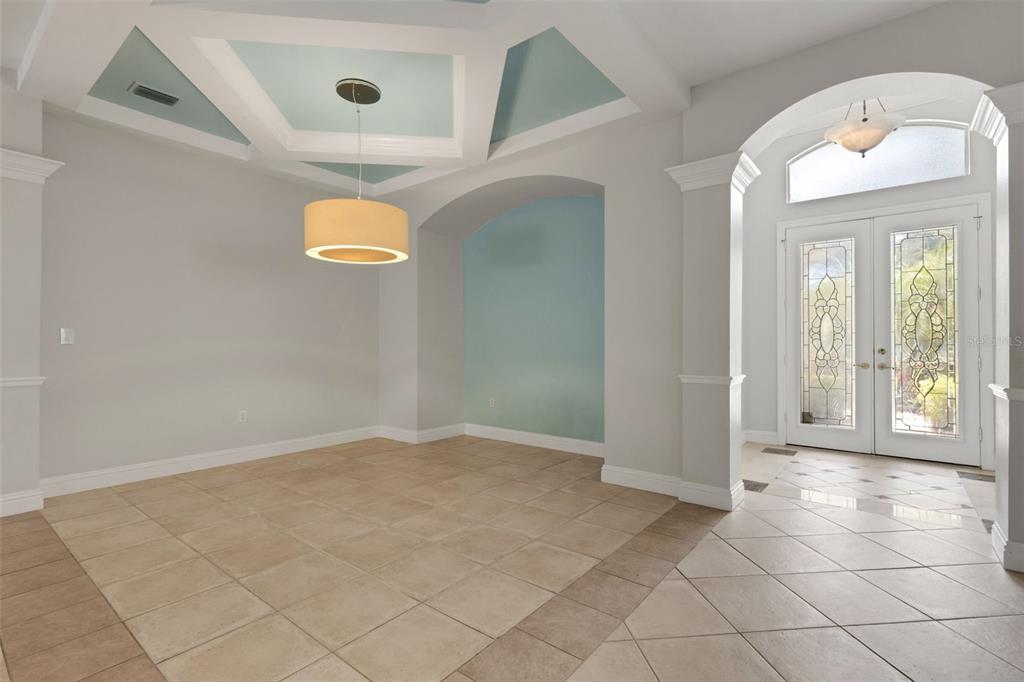 An entryway leads into a dining room with a coffered ceiling and light-colored tile floors — 299 TURQUOISE LANE, OSPREY, FL