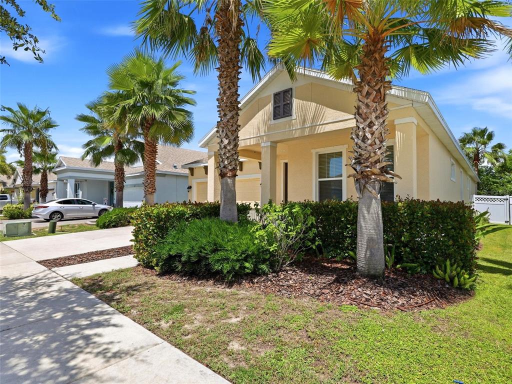 A light yellow house with a front porch, palm trees, and a concrete driveway — 5133 ADMIRAL POINTE DRIVE, APOLLO BEACH, FL