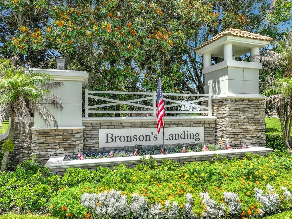 A stone and stucco entrance sign for Bronson's Landing features an American flag and landscaping — 2139 TILLMAN AVENUE, WINTER GARDEN, FL