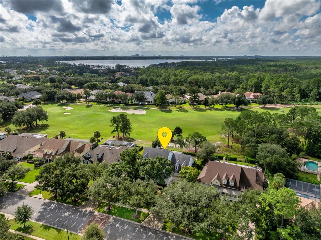 An aerial view shows a house with a yellow location pin overlooking a golf course — 8241 TIBET BUTLER DRIVE, WINDERMERE, FL