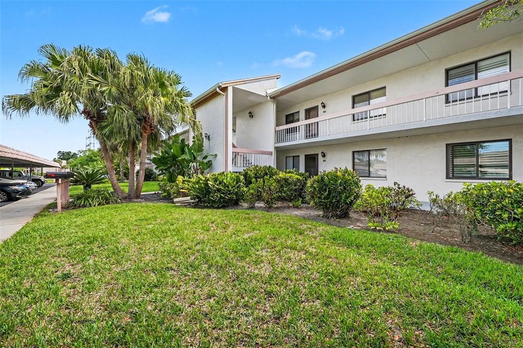 A two-story apartment building with a white exterior, a balcony, and a grassy front yard — 172 LAKEVIEW WAY UNIT 172, OLDSMAR, FL