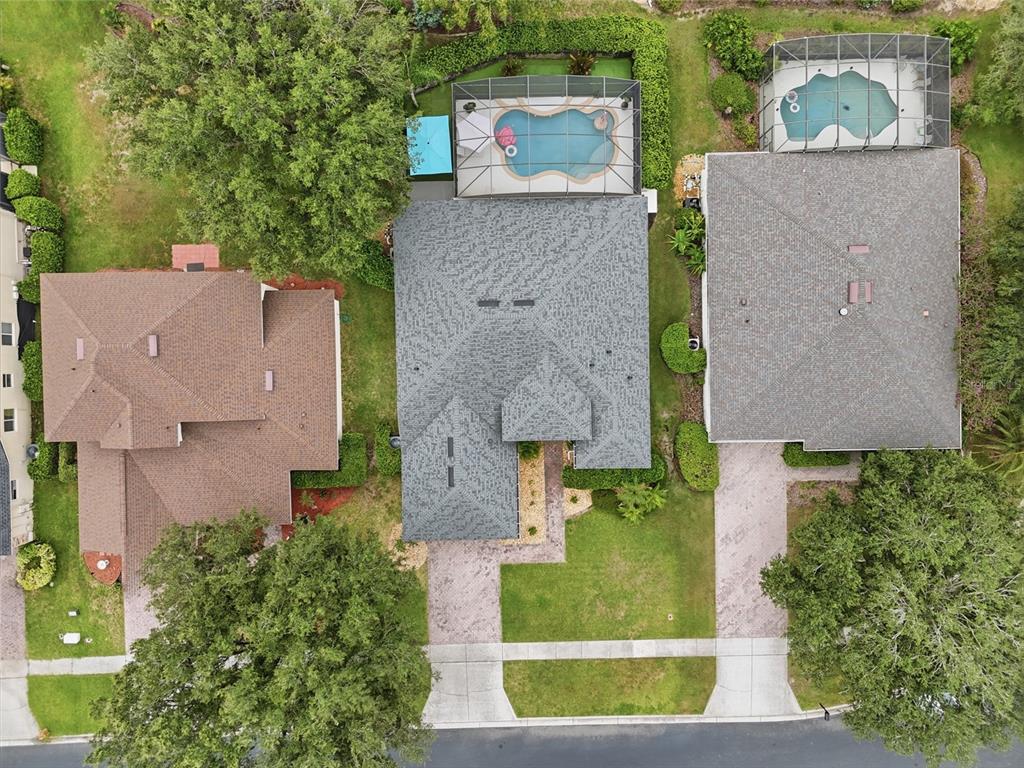 An aerial view shows three suburban houses with swimming pools and driveways from above — 3790 LIBERTY HILL DRIVE, CLERMONT, FL