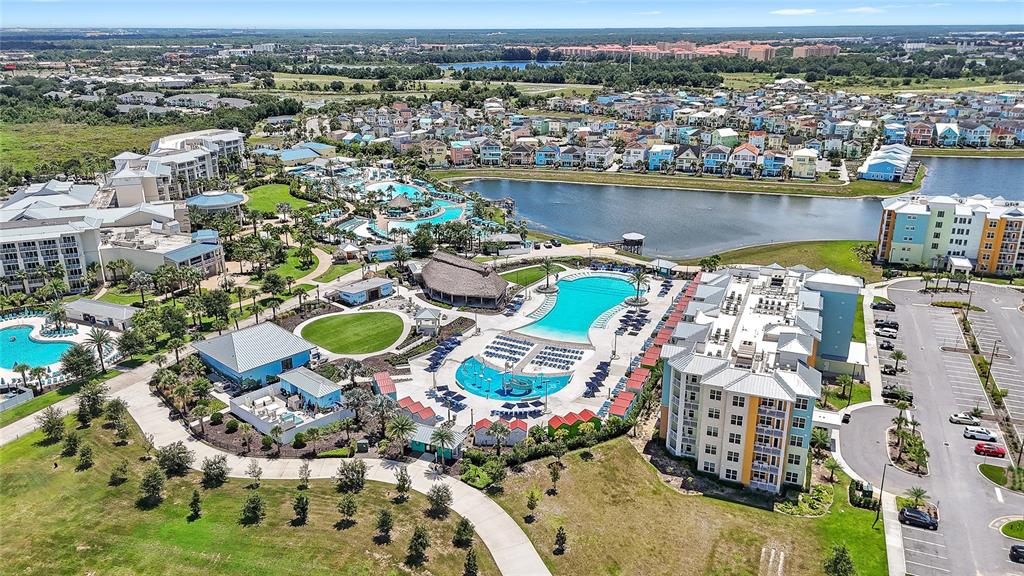 An aerial view shows a resort complex with swimming pools, multi-story buildings, and a lake — 3151 SUNSET WALK DRIVE UNIT 508, KISSIMMEE, FL