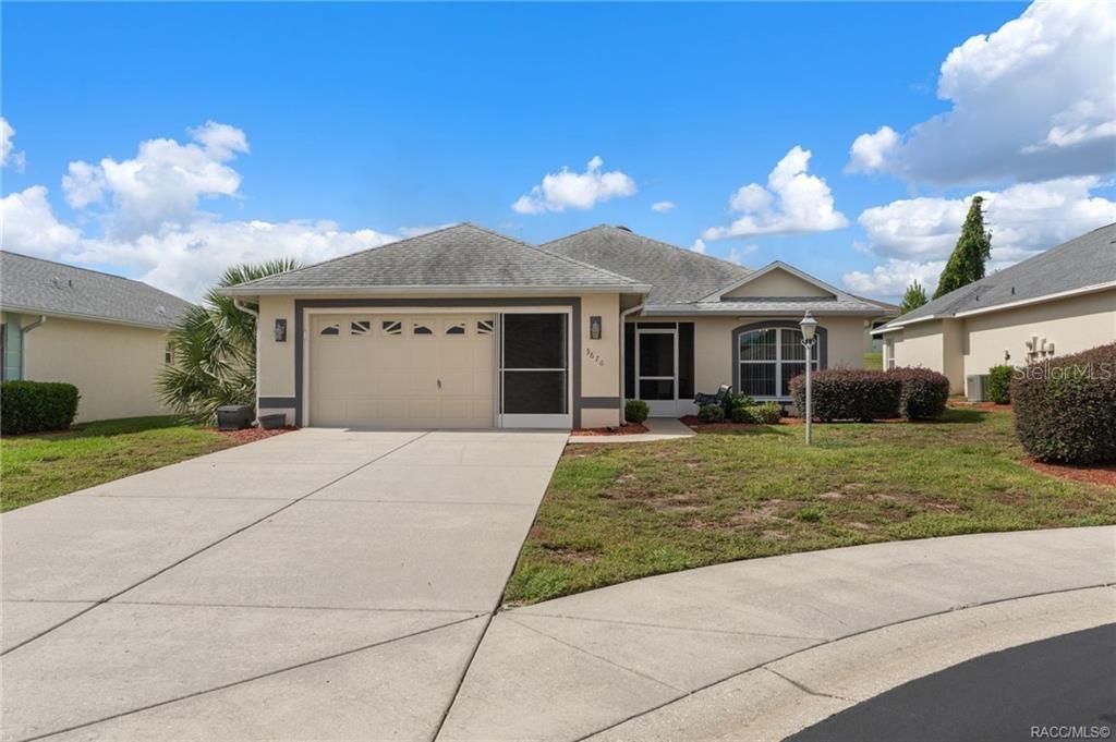A single-story suburban house with a two-car garage, a concrete driveway, and a front lawn — 3676 E IBIS COVE COURT, HERNANDO, FL