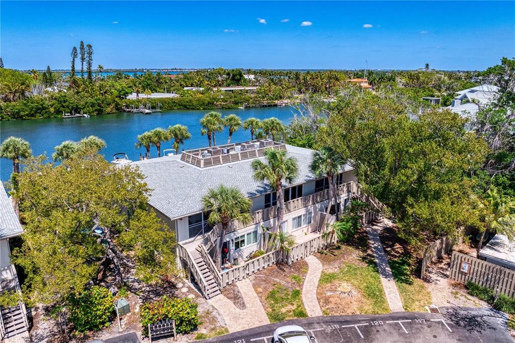 Aerial view of a coastal residential neighborhood with canals, a beach, and the ocean — 6700 GULF OF MEXICO DRIVE UNIT 118, LONGBOAT KEY, FL