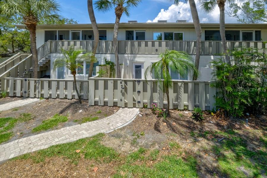 A living room with light tile floors, a tan leather sofa, and sliding glass doors — 6700 GULF OF MEXICO DRIVE UNIT 118, LONGBOAT KEY, FL