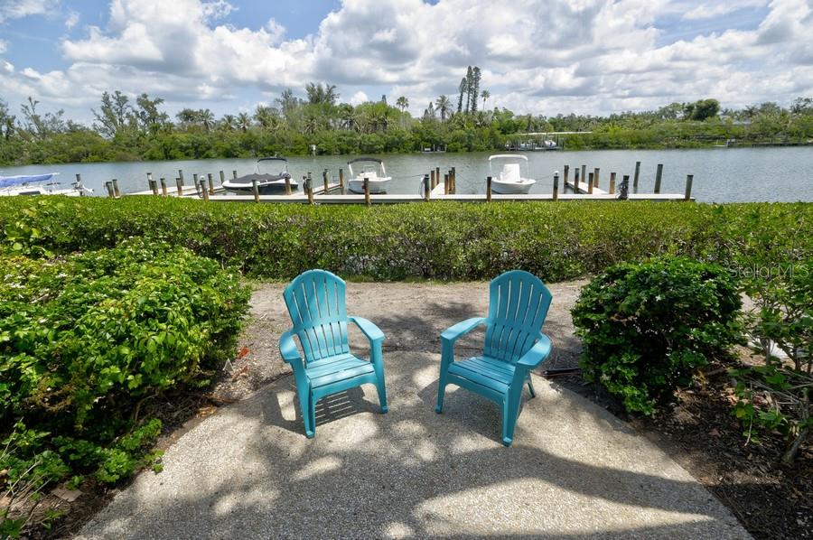 A kitchen with granite countertops overlooks a dining area and a patio with water views — 6700 GULF OF MEXICO DRIVE UNIT 118, LONGBOAT KEY, FL