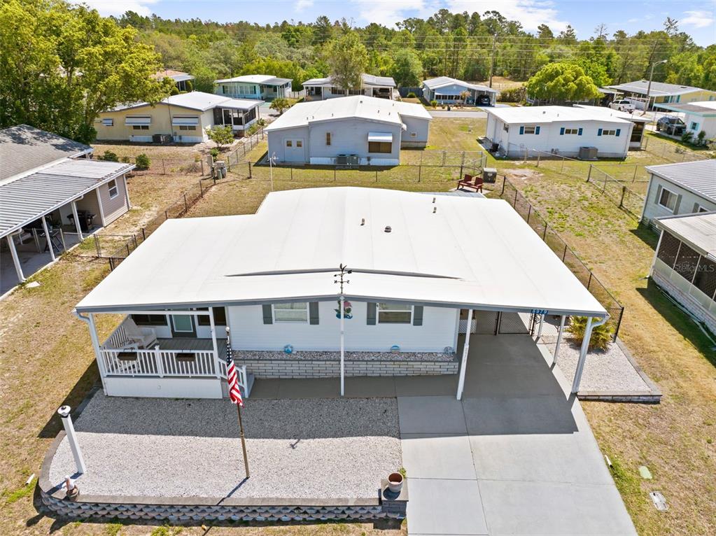 An aerial view shows a white manufactured home with a carport and a front porch — 8979 HIGHPOINT BOULEVARD, BROOKSVILLE, FL
