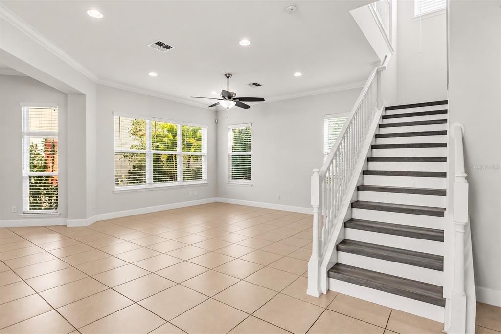 A kitchen with white cabinets, granite countertops, a tiled island, and stainless steel appliances — 12837 BOVET AVENUE, ORLANDO, FL