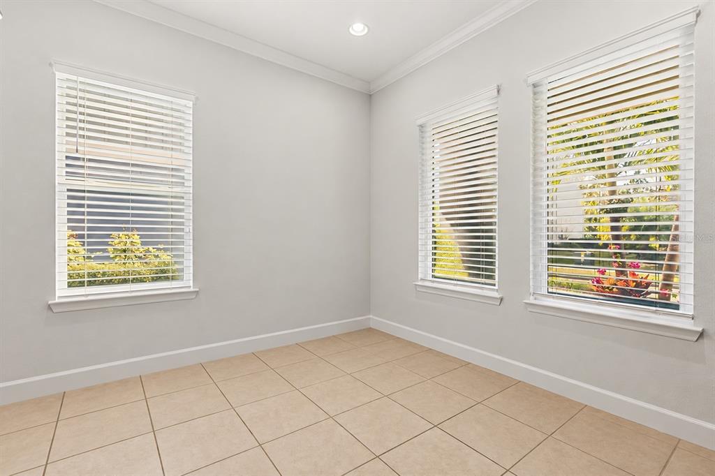 A covered patio features a ping pong table on a rug and red-framed glass doors — 12837 BOVET AVENUE, ORLANDO, FL