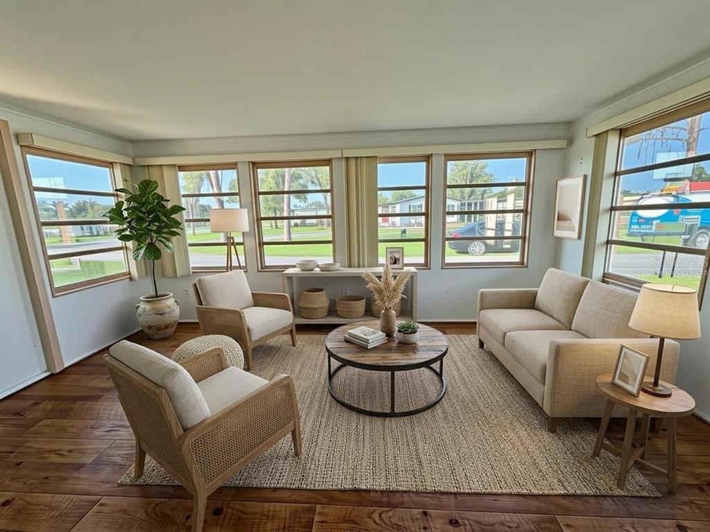 A sunroom features wood-look flooring, large windows, and a sliding glass door to another room — 416 PALO VERDE DRIVE, LEESBURG, FL