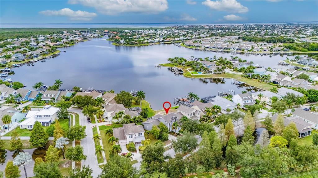 An aerial view shows a residential neighborhood with houses surrounding a large lake — 435 MANNS HARBOR DRIVE, APOLLO BEACH, FL