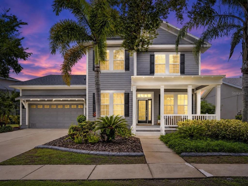 A two-story gray house with a front porch, a garage, and a palm tree — 435 MANNS HARBOR DRIVE, APOLLO BEACH, FL