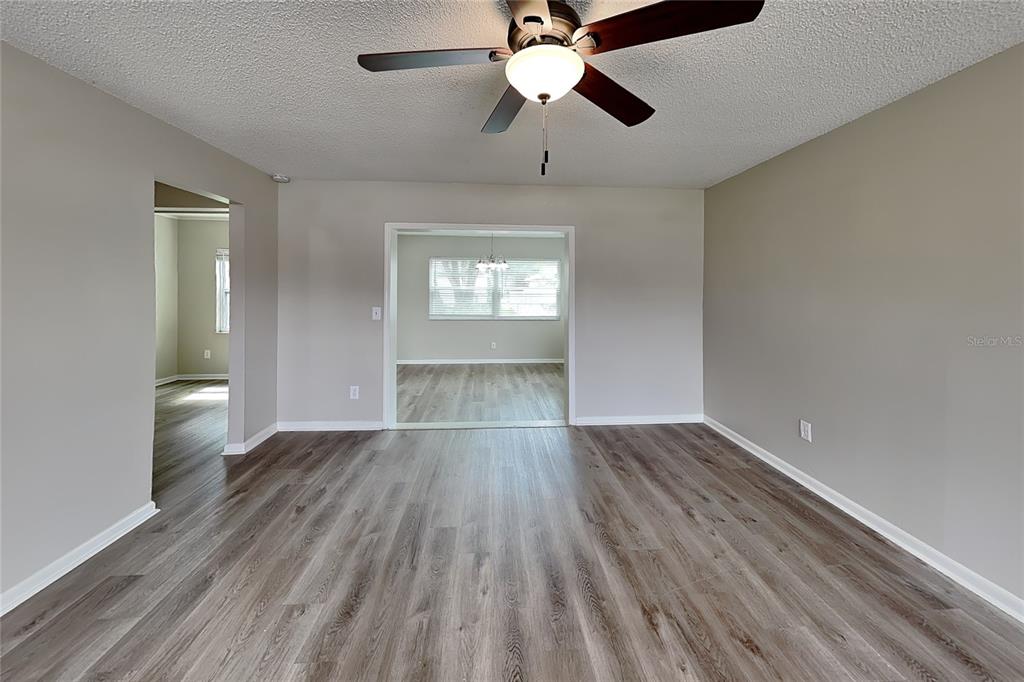 An empty room with light gray walls, wood-look flooring, and a ceiling fan — 1404 FERNWOOD PLACE, SEFFNER, FL