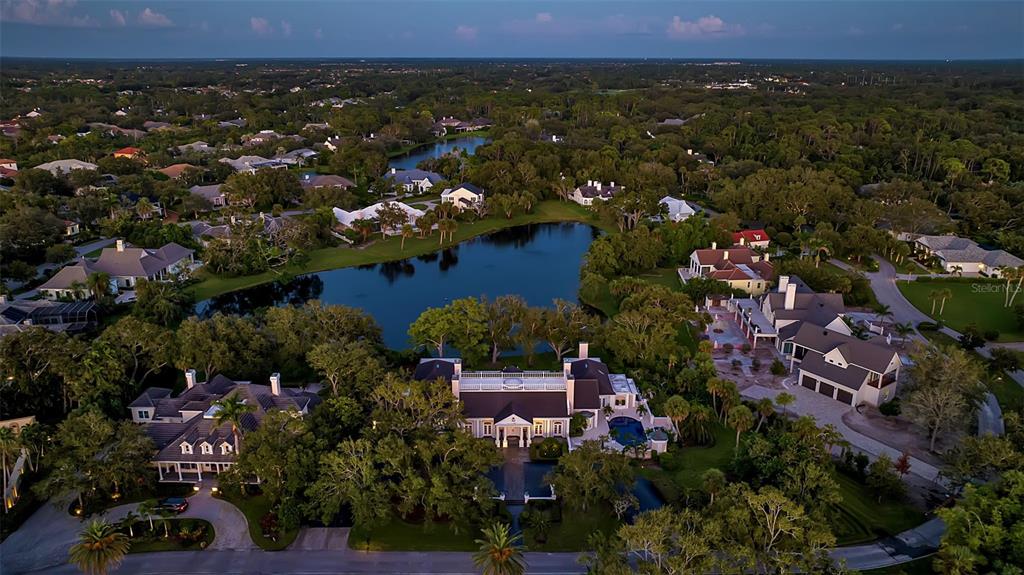 An aerial view of a large luxury estate with a pool overlooking a lake — 101 OSPREY POINT DRIVE, OSPREY, FL