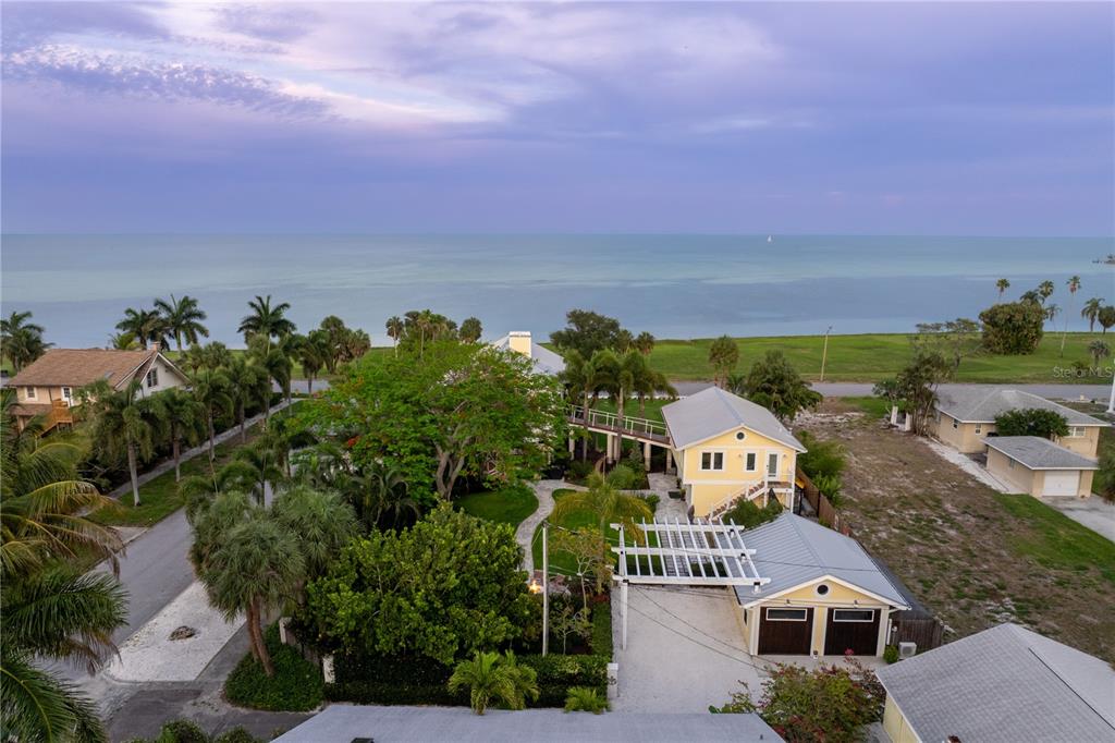 An elevated two-story house with a metal roof and wrap-around decks at twilight — 1803 BEACH DRIVE SE, ST PETERSBURG, FL