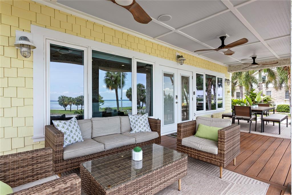 A view from a wooden porch looking out over a lawn toward the ocean — 1803 BEACH DRIVE SE, ST PETERSBURG, FL