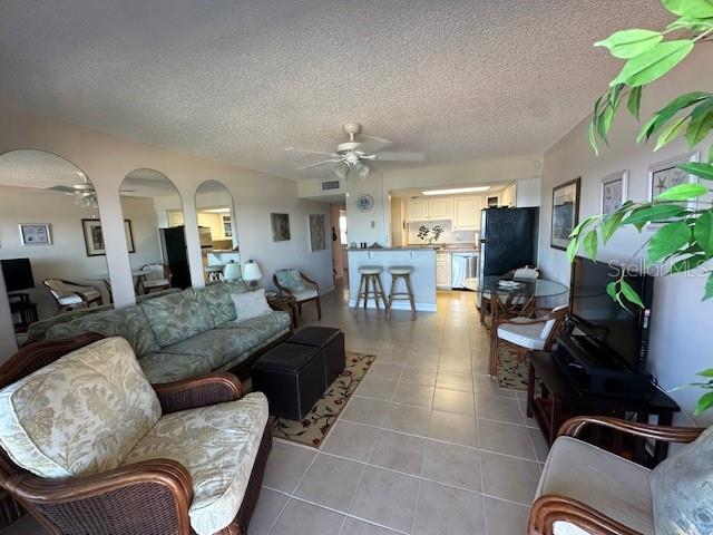 This living room features tile flooring, a ceiling fan, and a balcony with ocean views — 2700 OCEAN SHORE BOULEVARD UNIT 504, ORMOND BEACH, FL