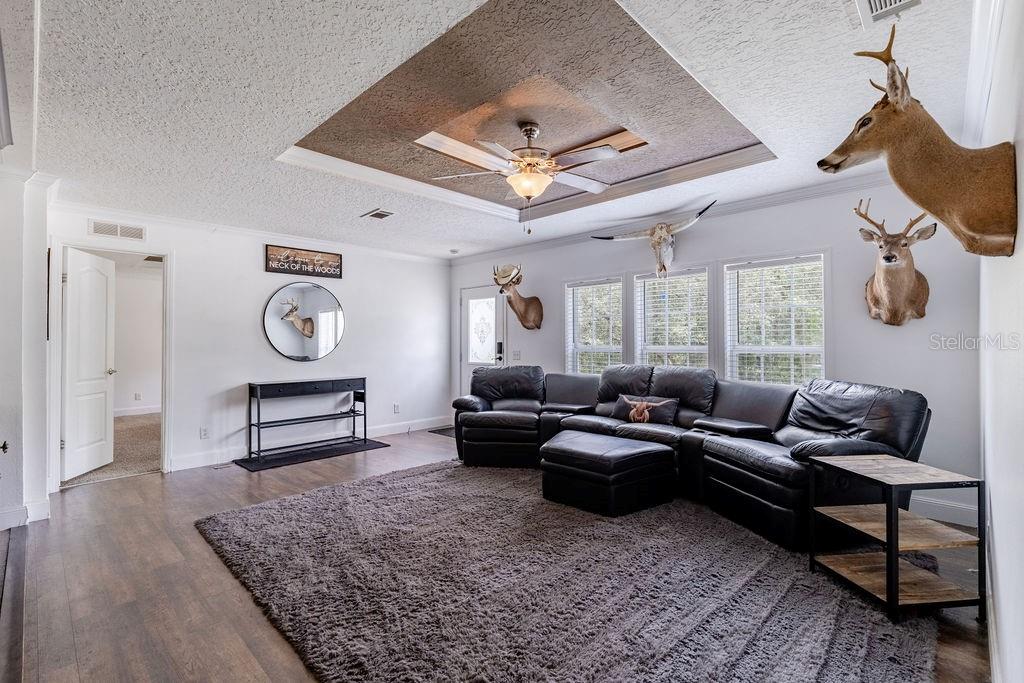 An entryway features a console table, a round mirror, and a deer mount on the wall — 24821 OLD DEER ROAD, PAISLEY, FL