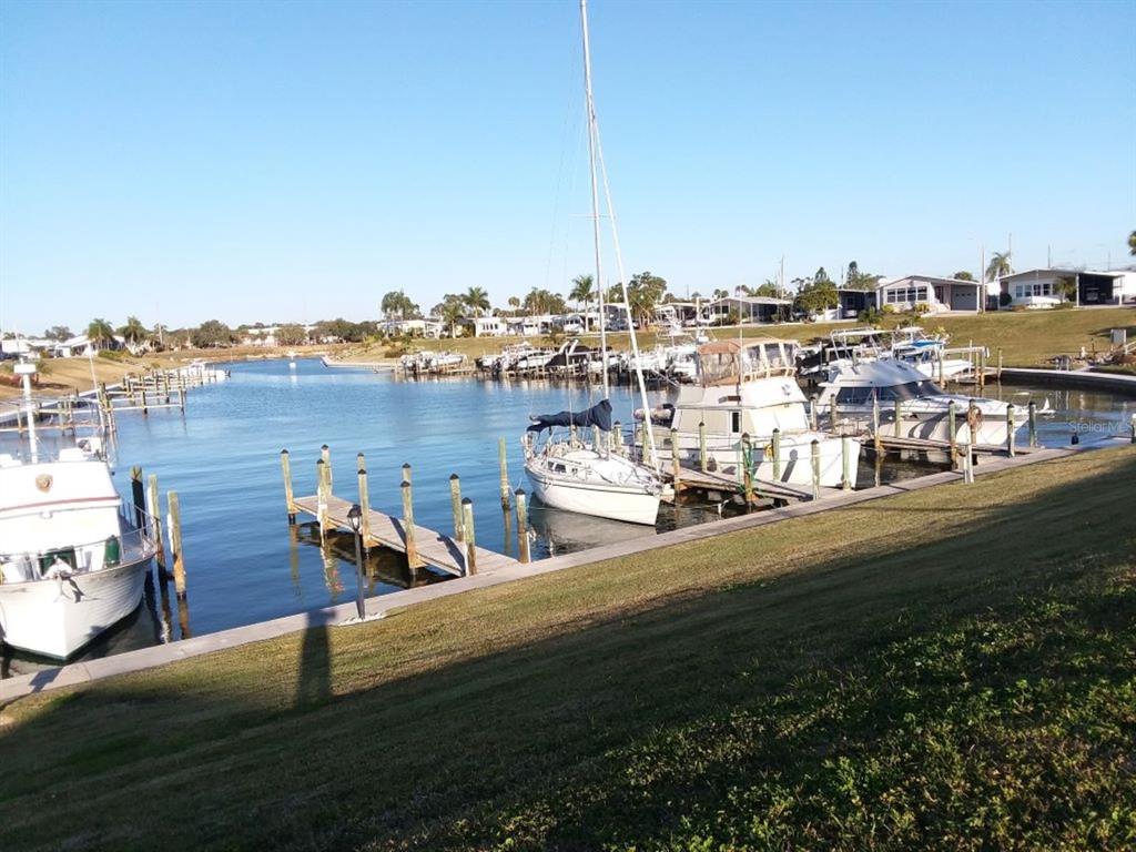 A marina with several boats docked along wooden piers under a clear blue sky — 811 BOGIE, VENICE, FL