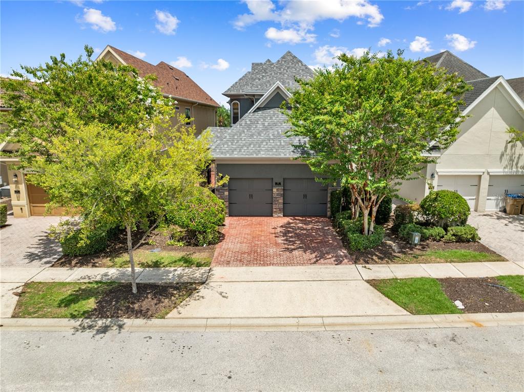 A two-story house with a two-car garage and a brick driveway sits between two neighbors — 785 GOLDEN BEAR DRIVE, REUNION, FL