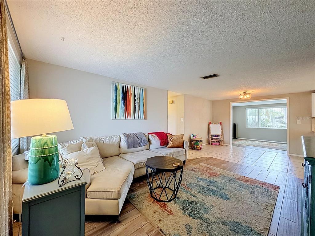 An aerial view shows a waterfront house with a wooden deck and palm trees — 2228 SOCIETY DRIVE, HOLIDAY, FL