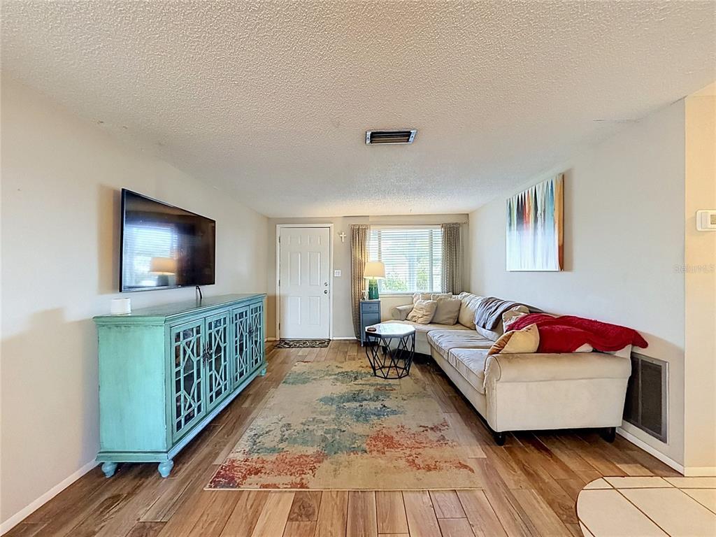 A wooden deck with white railings overlooks a lake under a palm tree — 2228 SOCIETY DRIVE, HOLIDAY, FL