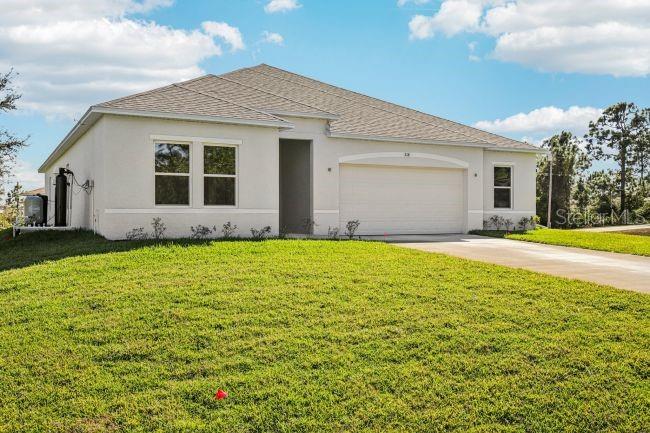 A single-story house with a light-colored exterior, a two-car garage, and a grassy yard — 16492 CRANE ROAD, WEEKI WACHEE, FL