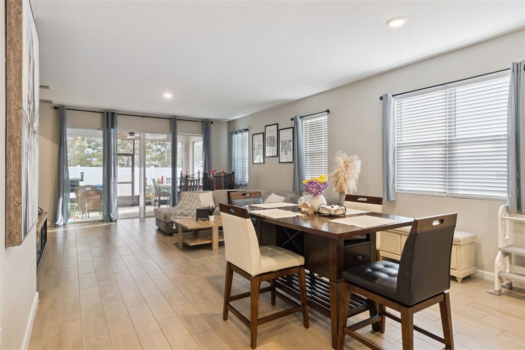 A dining area with a dark wood table sits adjacent to a living room space — 2849 CATHY BOULEVARD, WINTER HAVEN, FL
