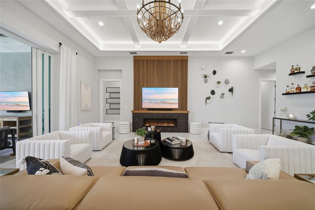 A modern kitchen features white cabinetry, a dark gray island with bar stools, and pendant lighting — 8254 PAVIA WAY, LAKEWOOD RANCH, FL